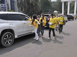Kade Golkar Kota bogor membagikan masker kepada pengendara.