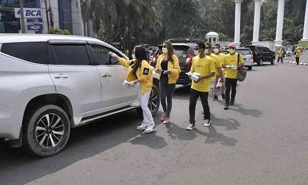 Kade Golkar Kota bogor membagikan masker kepada pengendara.