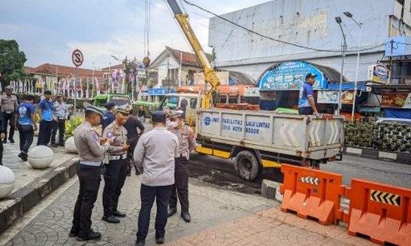 Petugas Dishub Kota Bogor membuka celukan untuk angkot berhenti. Foto: Bogorkita