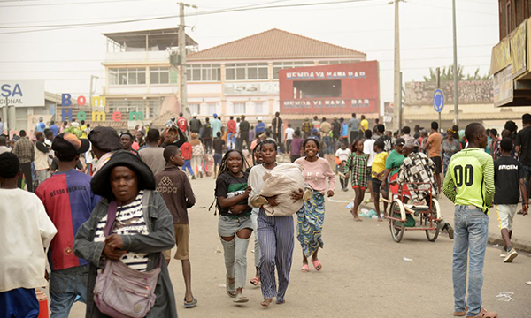 Sejumlah perempuan membawa barang-barang saat penjarahan meletus di distrik Kalemba 2, Luanda, Angola, pada Senin (28/7/2025), dalam aksi mogok oleh sopir taksi selama tiga hari untuk memprotes kenaikan harga bahan bakar. Penjarahan terjadi setelah sekitar 2.000 orang berunjuk rasa untuk memprotes kenaikan harga bahan bakar dan biaya transportasi.(AFP)