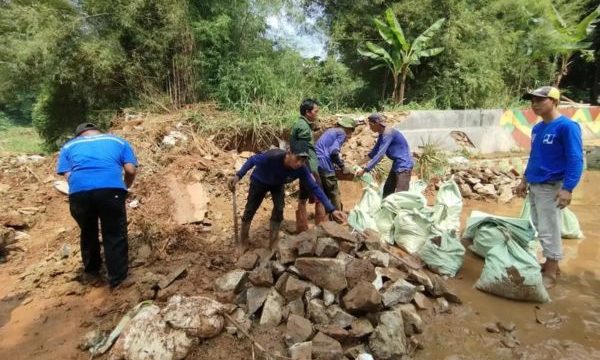 Petugas DPUPR dan Dinas Pemadam Kebakaran dan Penyelamatan (Damkar) Kota Depok membersihkan sisa-sisa lumpur dan sampah yang terbawa banjir, Senin (11/8/2025). (Foto: Depok.go.id)