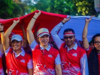 Forkopimda Kota Bogor dan Ketua PWI Kota Bogor Aldho Herman membawa bendera raksasas dalam kirab merah putih 2025. (Foto Kominfo Kota Bogor)