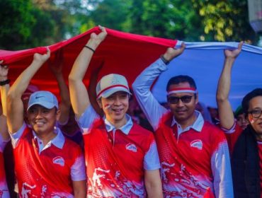 Forkopimda Kota Bogor dan Ketua PWI Kota Bogor Aldho Herman membawa bendera raksasas dalam kirab merah putih 2025. (Foto Kominfo Kota Bogor)