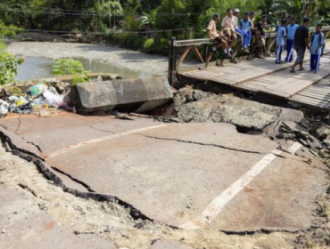 Sejumlah pelajar melintasi jembatan Siriwini Bawah yang rusak akibat gempa di Kabupaten Nabire, Provinsi Papua Tengah, Jumat (19/9). (Foto: ANTARA FOTO/Jack)