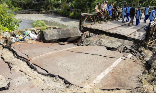 Sejumlah pelajar melintasi jembatan Siriwini Bawah yang rusak akibat gempa di Kabupaten Nabire, Provinsi Papua Tengah, Jumat (19/9). (Foto: ANTARA FOTO/Jack)