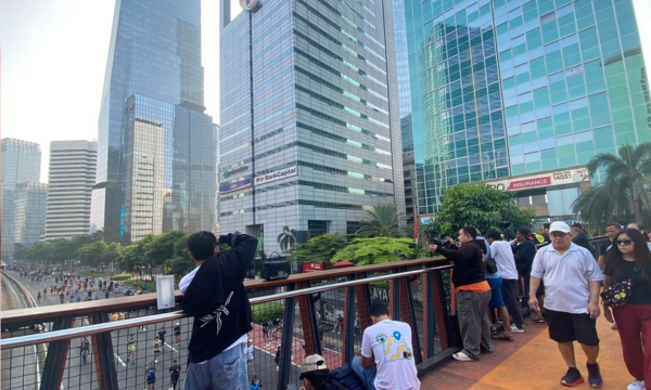 Fotografer pelari berjejer di Jembatan Penyeberangan Orang (JPO) Karet, Jakarta Pusat, Minggu (13/4/2025).(Foto: Hanifah Salsabila)
