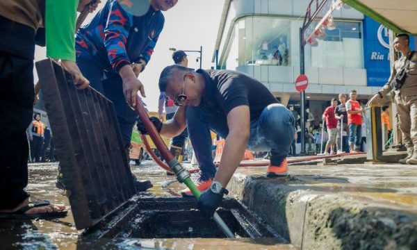 Wakil Wali Kota Bogor Jenal Mutaqien tengah membersihkan selokan di Jalan Surken. (Foto: Kominfo)