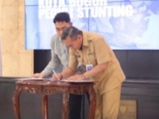 Kepala DPPKB Kota Bogor Marse Saputera menandatangani komitmen kolaborasi tekan stunting. (foto: ist)