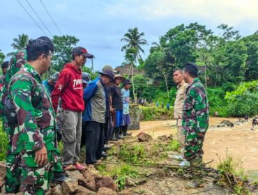 TNI dan warga kompak bangun jembatan. (foto: puspen TNI)