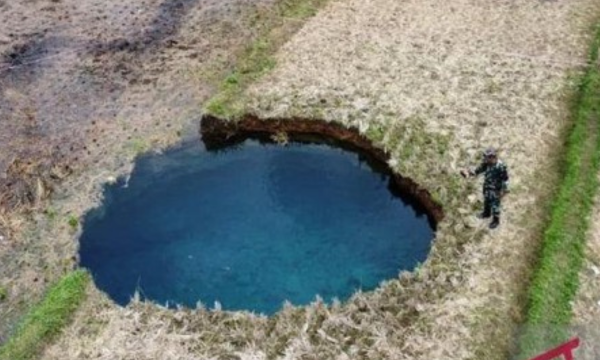 Foto: Warga melihat dari jauh sinkhole di Nagari Situjua Batua, Limapuluh Kota, Sumbar. (Antara/Fandi Yogari)